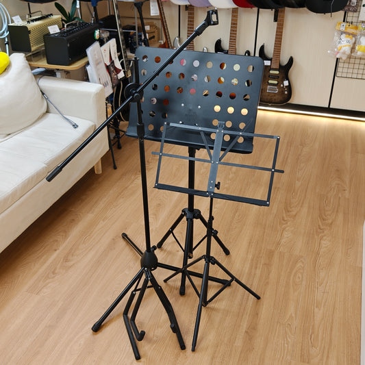 Music stand with microphone stand on a wooden floor in a room with musical instruments.