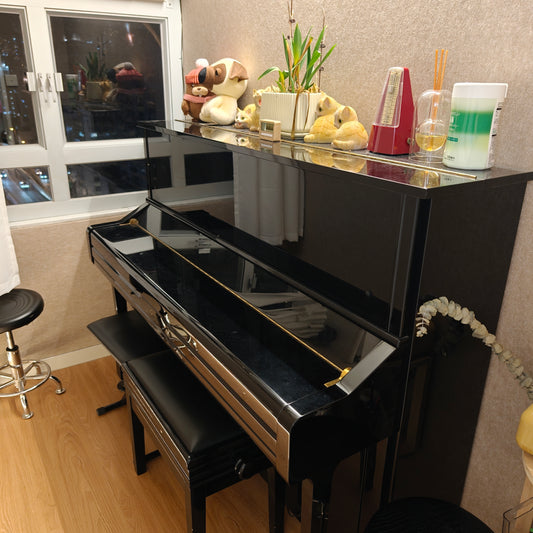 Black piano in a room with decorative items on top 旺角租Band房 旺角Band Room Band Room Rental 電子鼓房 租電子琴房 租結他房 租木結他房 租電結他房 租教學房 租樂器房 樂室租借